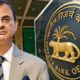 RBI Governor Sanjay Malhotra standing, with the Reserve Bank of India logo visible on the other side.