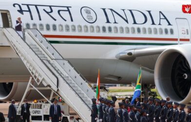 Prime Minister Narendra Modi stepping down from an aircraft and greeting with a Namaskar gesture