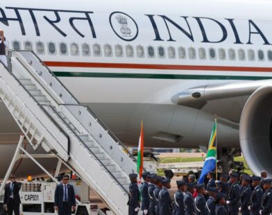 Prime Minister Narendra Modi stepping down from an aircraft and greeting with a Namaskar gesture