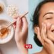 Woman touching her smooth face with a bowl of oats and honey beside her