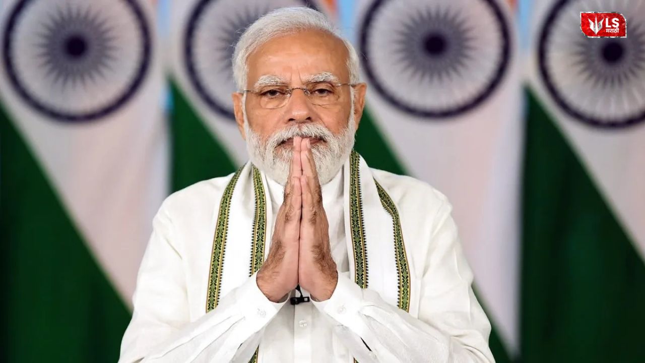 An Indian political leader standing with folded hands in front of national flags during an official event
