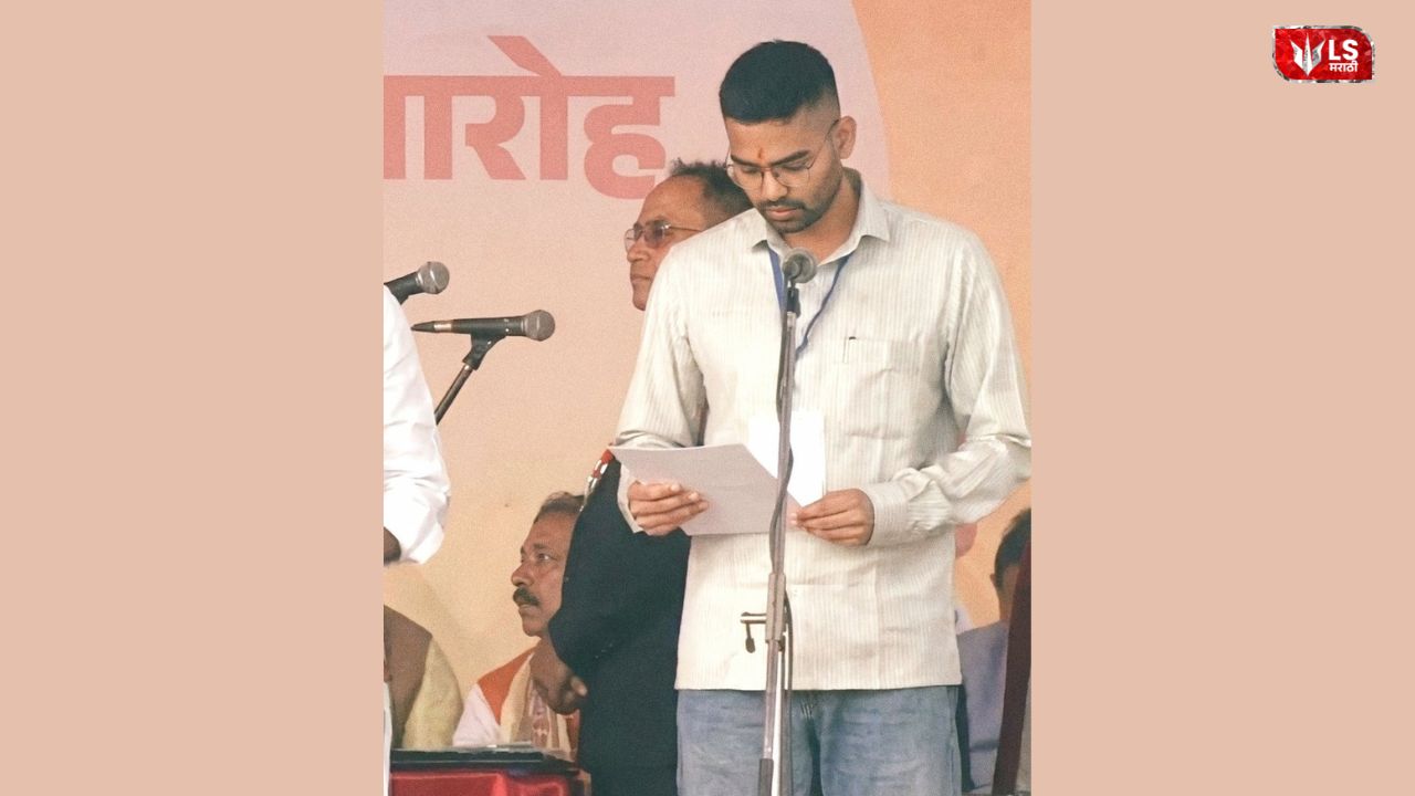 A man reading from a document while taking oath at a swearing-in ceremony on stage