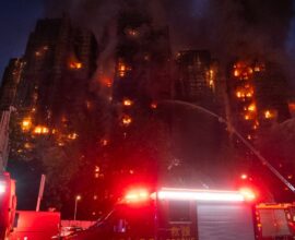 Smoke rising from high-rise buildings in Hong Kong after a massive fire with rescue teams at the scene