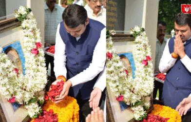 Devendra Fadnavis paying tribute to Dr. Babasaheb Ambedkar by offering flowers and garlanding his photo during a memorial event