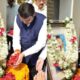 Devendra Fadnavis paying tribute to Dr. Babasaheb Ambedkar by offering flowers and garlanding his photo during a memorial event